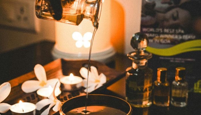 A tranquil scene of aromatherapy with pouring oil, candles, and a soothing atmosphere.